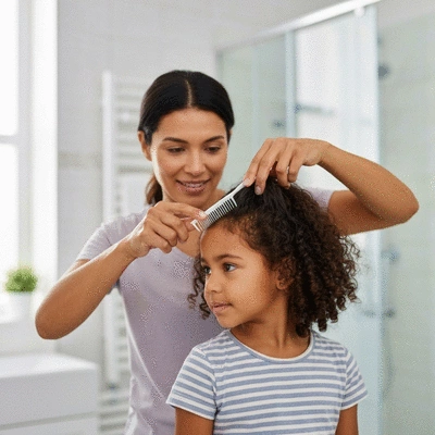 Parent applying a head lice treatment product to a child's hair